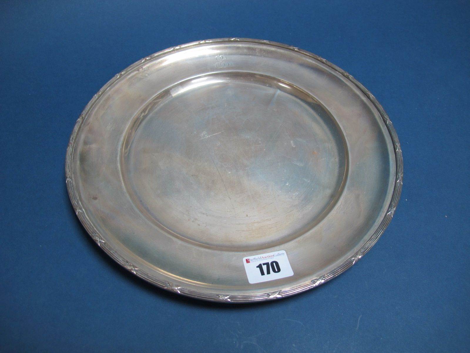 A Plate, of plain circular form with ribbon and reed style border, initialled, stamped "Perera" "
