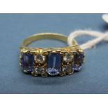 An 18ct Gold Tanzanite and Diamond Set Dress Ring, claw set with three emerald cut tanzanites,