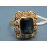 A Sapphire and Diamond Cluster Ring, rectangular collet set to the centre, within shaped border of