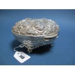 A Decorative Middle Eastern Lidded Box, of oval form, allover detailed in relief, raised on four