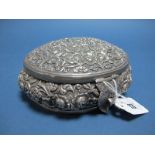 A Middle Eastern Lidded Box, of oval form, allover detailed in relief with foliate scrolls, the
