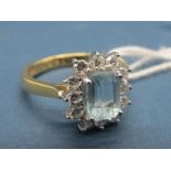 An 18ct Gold Aquamarine and Diamond Cluster Ring, rectangular set to the centre, within claw set