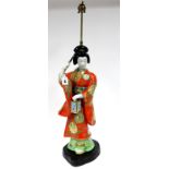 A Mid XX Century Japanese Porcelain Table Lamp, modelled as a Geisha holding a lantern and a fan,
