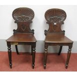 A Pair of XIX Century Mahogany Hall Chairs, each with carved shell backs and solid seats, on