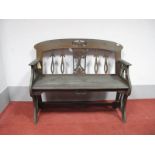 An Art Nouveau Oak Bench, with stylised flower pierced splat, shaped arms, solid seat with moulded
