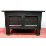 A XVII Century Joined Oak Blanket Box, with twin panels to the hinged lid, the base with carved