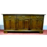 A Nigel Griffiths Oak Dresser Base, with three top drawers over three panelled cupboard doors, on