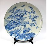 A Late XIX Century Japanese Pottery Charger, painted in blue with birds perched on flowering peony