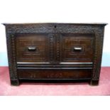 A XVII Century Joined Oak Blanket Box, the top with moulded edge and carved frieze, twin panelled