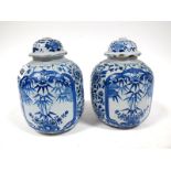 A Pair of XIX Century Tin Glaze Jars and Covers, (finials missing), of ovoid form, painted in blue