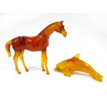 A Modern Reconstituted Amber Figure of a Dolphin, 29cm long; Another, modelled as a horse, 30cm