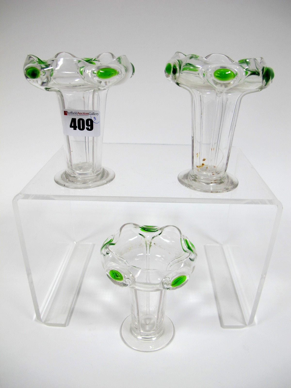 A Set of Three Art Nouveau Glass Vases, of fluted tapered form with outcurved wavy rim with green