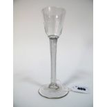 An XVIII Century Wine Glass, the part fluted tapered bowl raised on air twist stem and circular