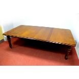 A Mid XIX Century Oak Wind-Out Table, the top with moulded edge, on turned and reeded legs (with two