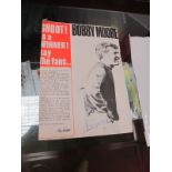 A Bobby Moore Autograph, blue ink signature, on a magazine print of him in West Ham Strip. A