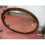 A Late XIX Century Oval Bevelled Wall Mirror, in mahogany frame.