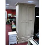 A Cream Painted Wardrobe, with twin panelled doors over a long drawer, plinth base; together with