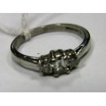 A Platinum Three Stone Diamond Ring, claw set between plain shoulders.