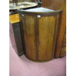 An Early XIX Century Oak and Mahogany Bow Fronted Corner Cupboard, with three internal drawers.