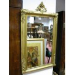 A Rectangular Bevelled Glass Wall Mirror, in cushion gilt frame, moulded foliate corners, all
