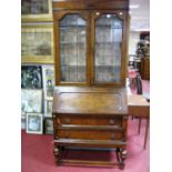 An Early XX Century Oak Bureau Bookcase, stepped pediment over shaped leaded glass doors, above fall