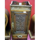 An Early XX Century Oak Smokers Cabinet, with a brass pierced grille, panelled door, with flower