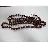 A Cherry Amber Bead Necklace, of uniform roundel form, 35cm long, together with another and a