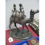 A Middle Eastern Model of a Camel, with male and female riders, detailed in relief, on oval base