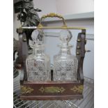 A Brass Mounted Tantalus, having twin hobnail glass decanters, with key.