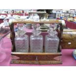 An Early XX Century Oak Tantalus, with plated mounts, three hobnail decanters (one damaged), key