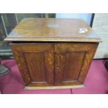 An Early XX Century Oak Smokers Cabinet, the top with silver mounts, moulded edge, twin panel doors,