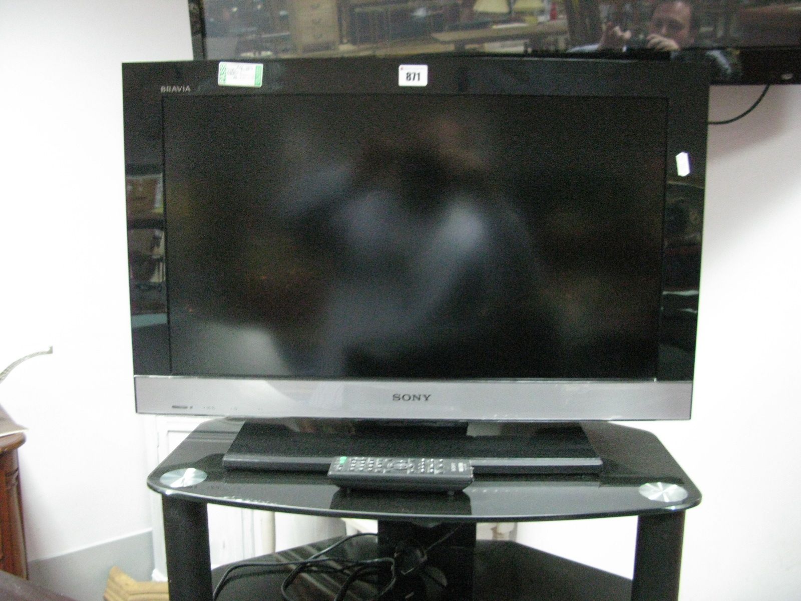 A Sony Bravia 26" TV, with remote and stand.