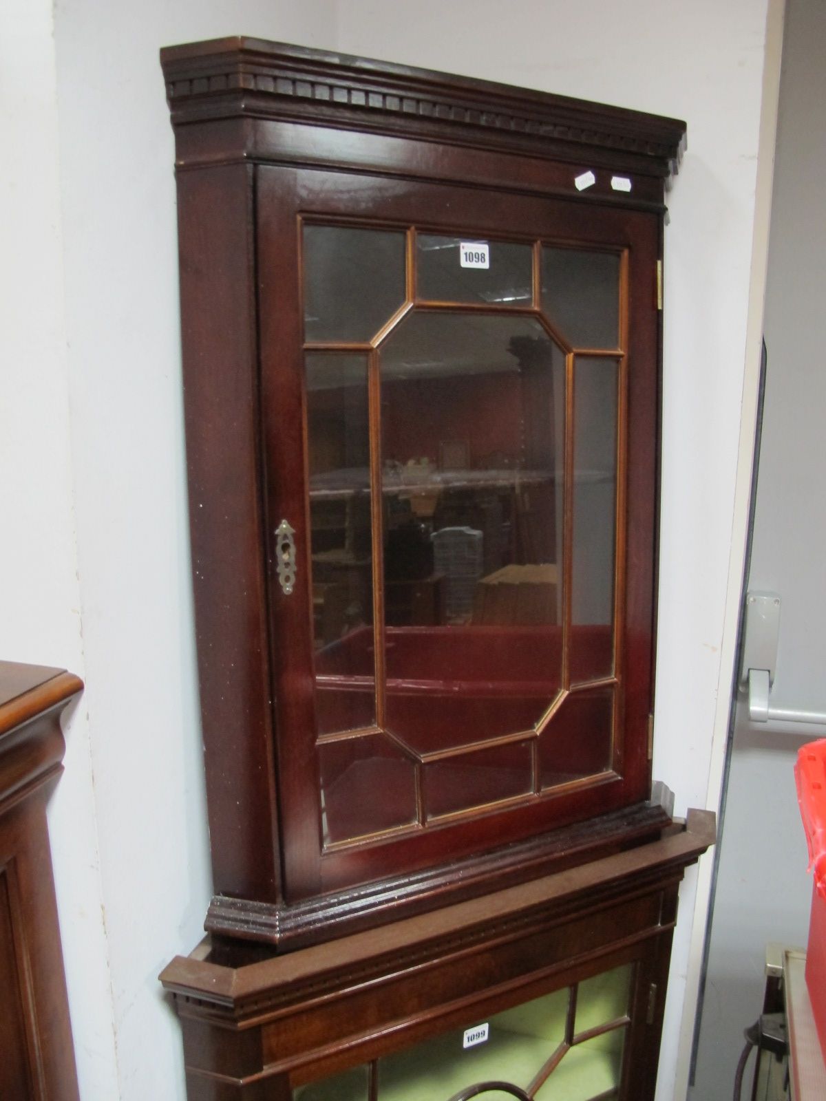 A Mahogany Hanging Corner Cupboard, astragal glazed door under dentil cornice.