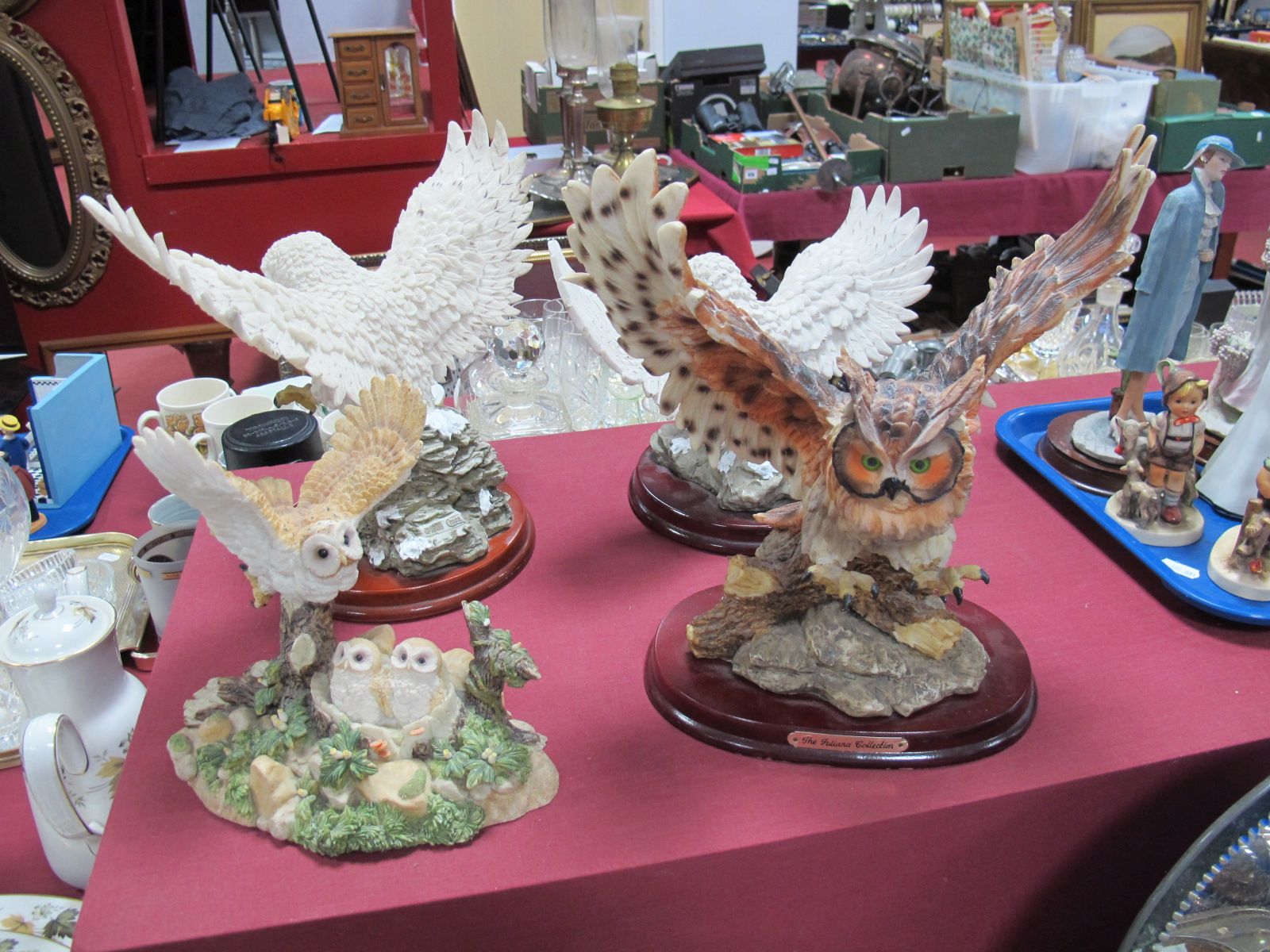Three Juliana Collection Resin Owls, on wooden stands, a similar owl family group.