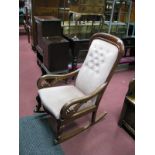 A XIX Century Mahogany Rocking Chair, with scrolled open arms and French style cabriole legs, the