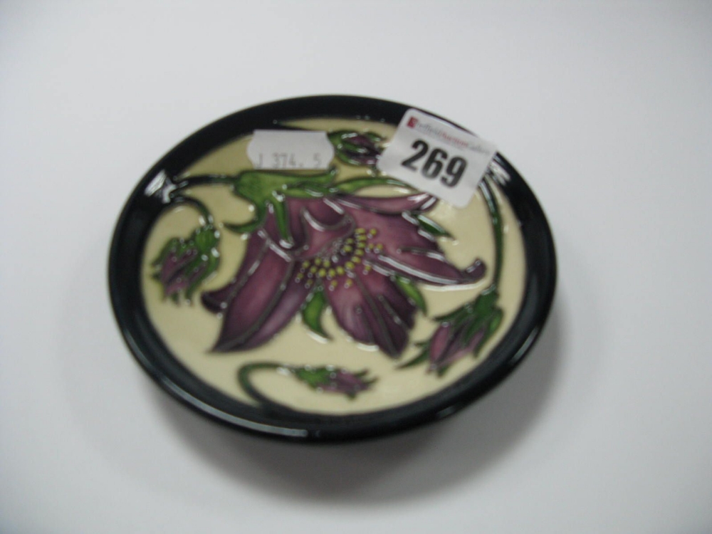 A Moorcroft Pottery Coaster, in the Pulsatilla design by Rachel Bishop, shape 780/4, impressed and