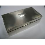 A Hallmarked Silver Cigarette Box, the rectangular engine turned lid initialled "J.W.B", inscribed