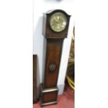 A 1920's Oak Grandmother Clock, with an arched hood, silvered dial, trunk with applied decoration,