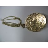A Large 9ct Gold Oval Locket Pendant, leaf scroll engraved to the front, on a chain.