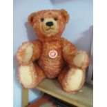 A Modern Steiff Classic Teddy Bear 'Sitting Down', red, with tags, 000218. Small hole noted on the