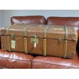 A Hessian Luggage Trunk, with leather corners and handles, wood rail enforcers.