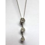 An 18ct White Gold Triple Cluster Drop Pendant, of uniform design, claw set on knife edge bars, on