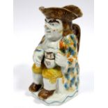 An Early XIX Century Prattware Toby Jug, the seated toper holding a jug of ale on his left knee, a