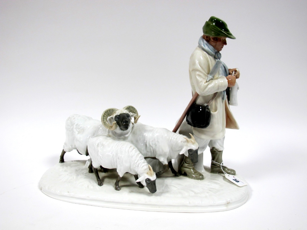 An Early/Mid XX Century German Porcelain Model of a Shepherd Standing Knitting Beside Three Sheep,