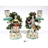 A Pair of XIX Century Chelsea Style Porcelain Figural Candlesticks, modelled as a lady and