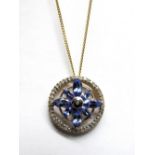 A Tanzanite and Diamond Openwork Pendant, claw set to the centre, of flowerhead design, within