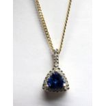 An 18ct Gold Tanzanite and Diamond Cluster Pendant, the central triangular mixed cut tanzanite