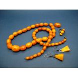 A Single Strand Amber Bead Necklace, composed of graduated oval beads; Together with Another