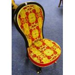 A Victorian ebonised nursing chair, with needlepoint upholstery,