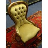 A reproduction spoon back armchair, upholstered in beige button back velour,